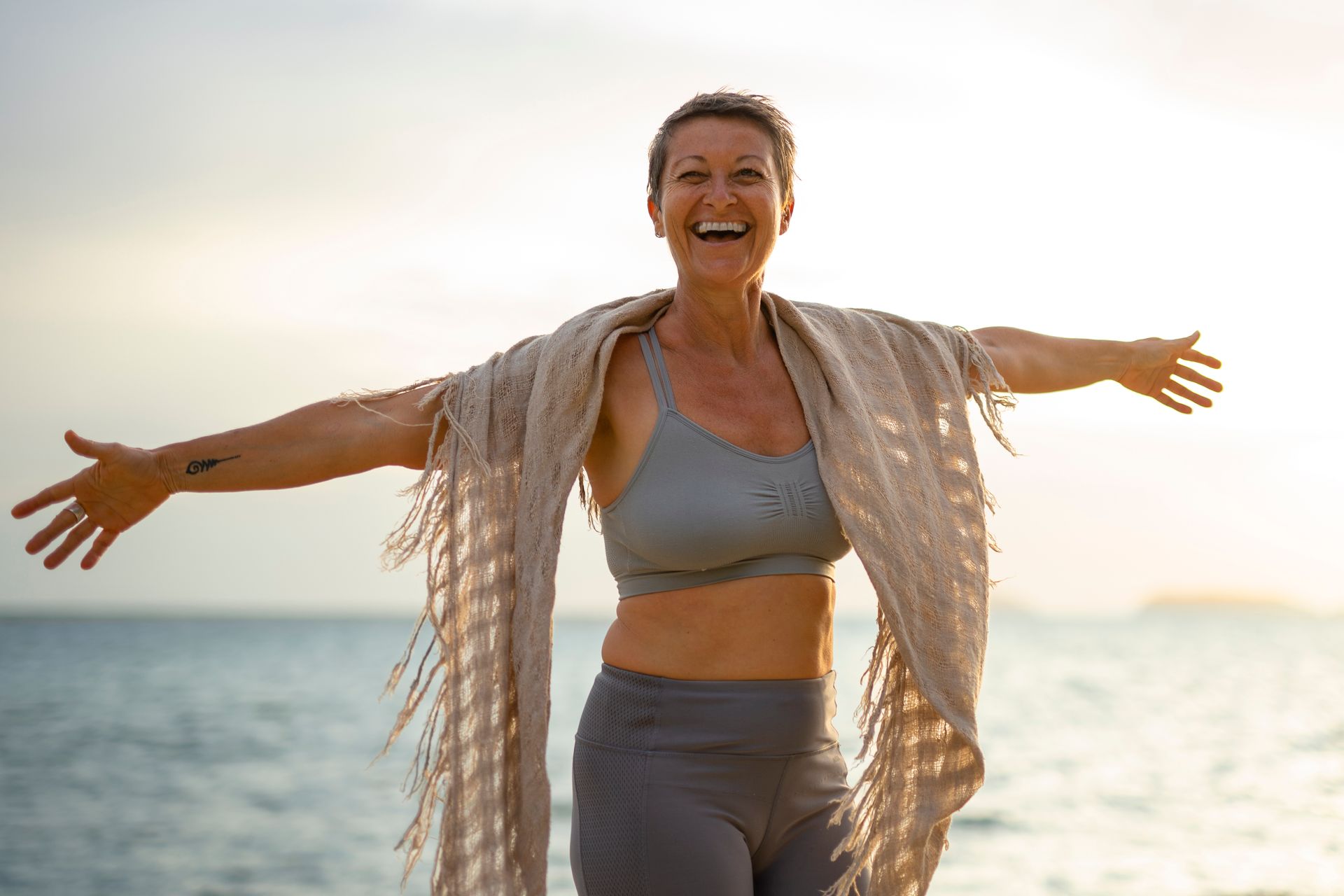 a woman is smiling with her eyes closed and her hands on her face