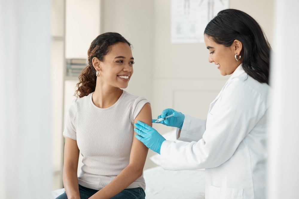 A woman is getting an injection in her arm from a doctor.