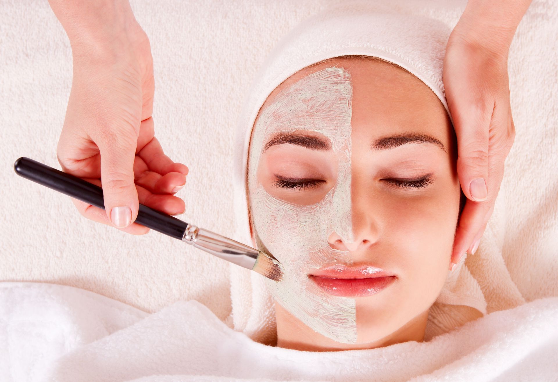 a woman is getting a facial treatment with a brush