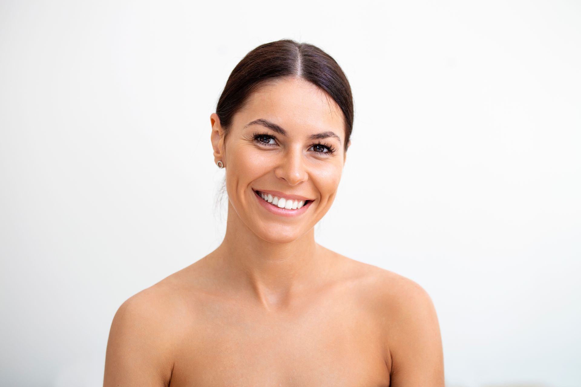 a woman without a shirt is smiling and looking at the camera