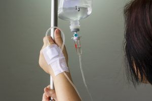 Person receiving intravenous fluids in a hospital setting.