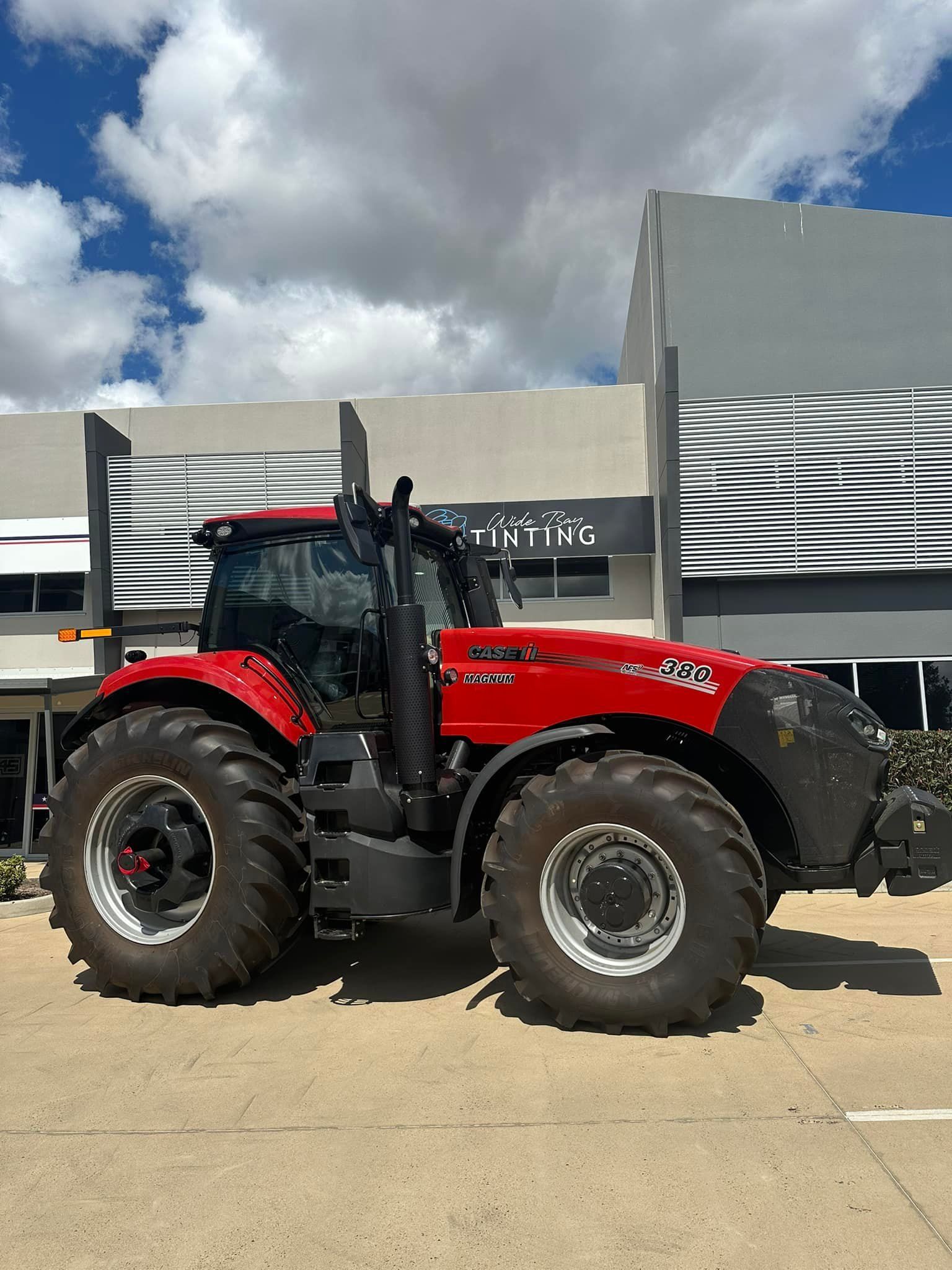 Red Case IH Magnum Tractor Parked Outside a Building on a Sunny Day — Wide Bay Tinting in Childers, QLD