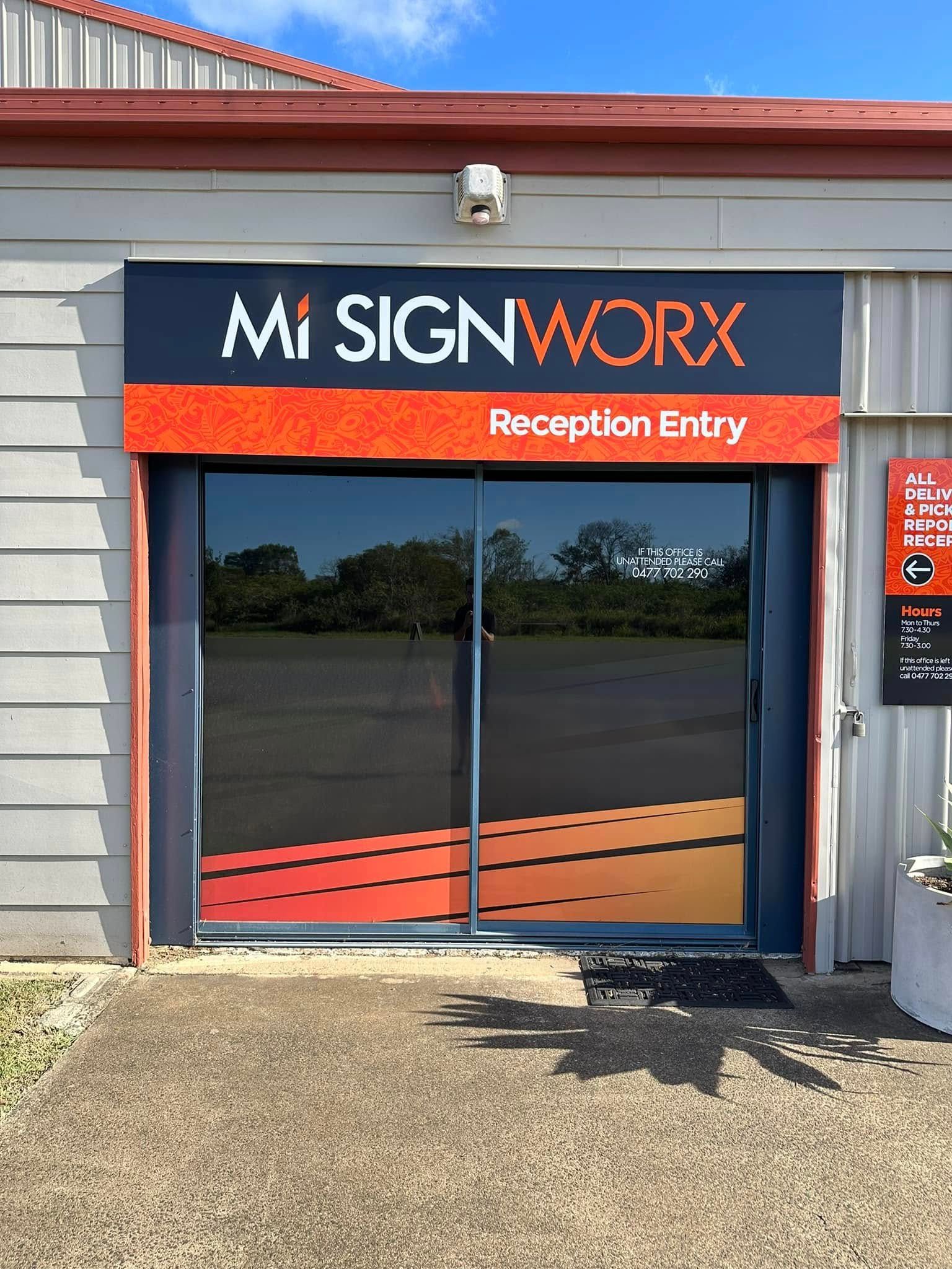 Mi Signworx storefront with black and orange signage above glass doors — Wide Bay Tinting in Kensington, QLD