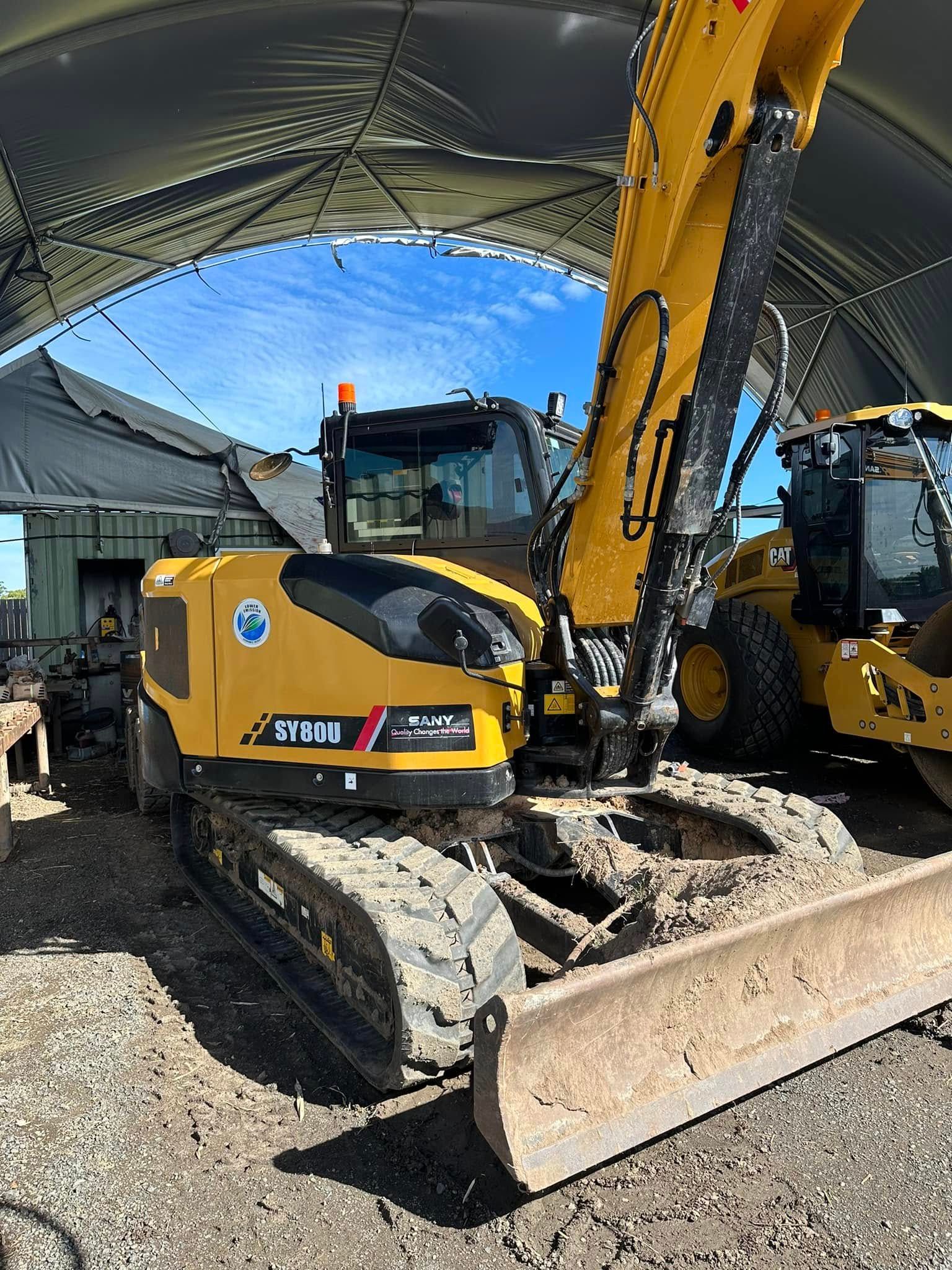 Yellow Excavator With Tracks, a Blade, and Cab, in an Open-air Enclosure — Wide Bay Tinting in Gin Gin, QLD