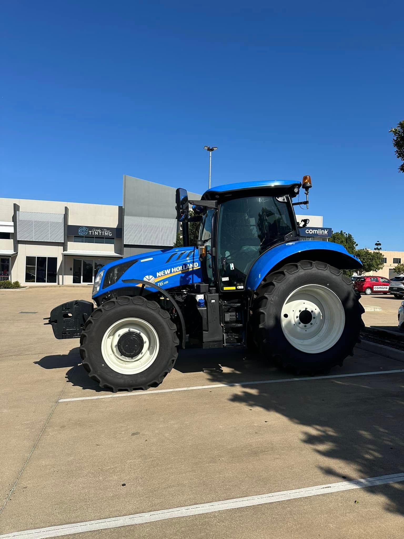 Blue New Holland Tractor Parked in a Parking Lot on a Sunny Day — Wide Bay Tinting in South Kolan, QLD