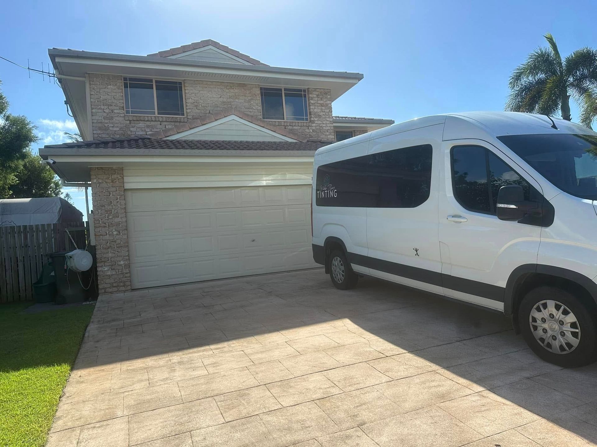 White Van Parked in Front of a Two-story Beige Brick House — Wide Bay Tinting in Bargara, QLD
