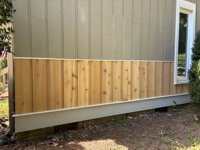 Wooden siding installed on the lower portion of a house exterior.