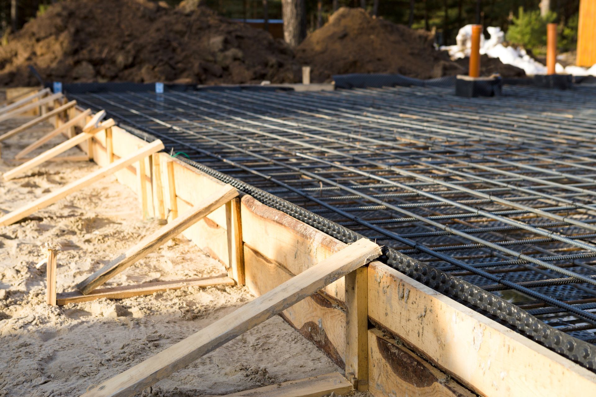 Wooden forms and rebar grid prepped for pouring a concrete foundation.