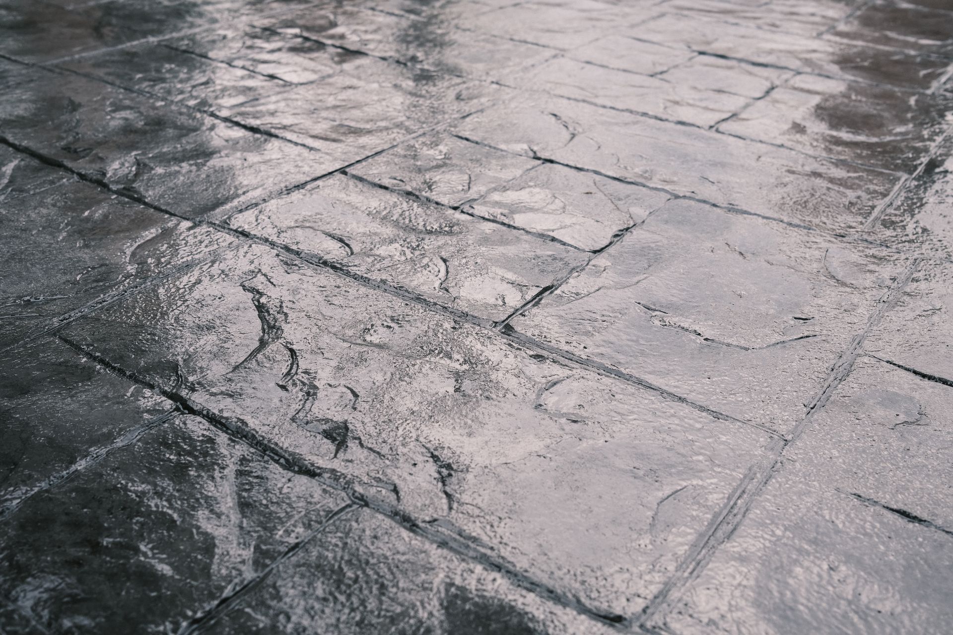 Wet, textured concrete patio with a stone pattern.