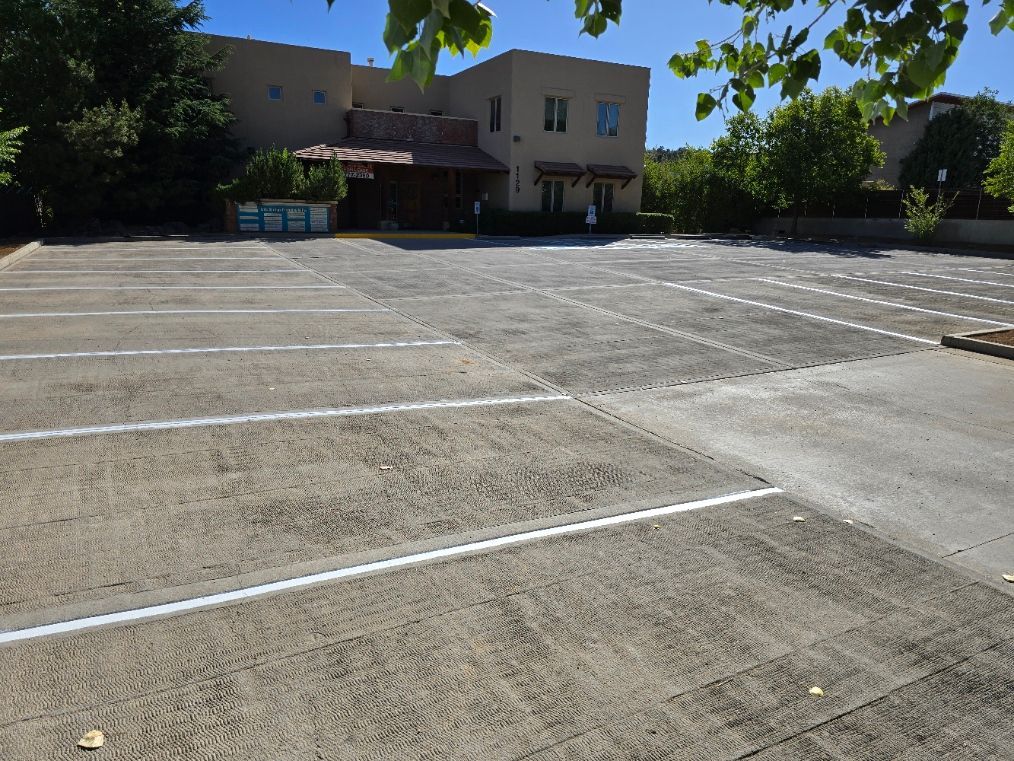 Empty parking lot in front of a beige building on a sunny day
