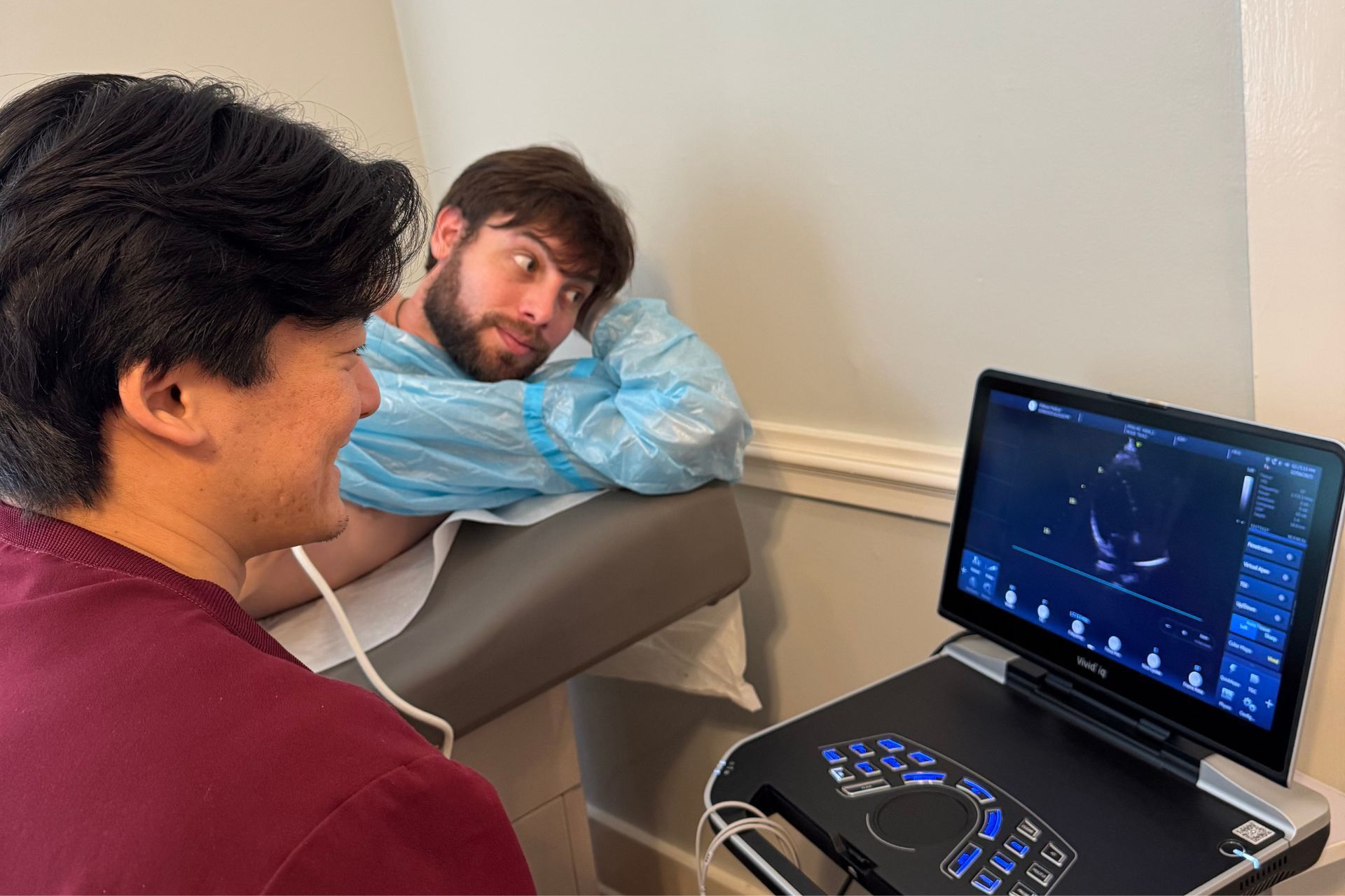 Two healthcare workers reviewing a clipboard and smiling in a bright clinic.