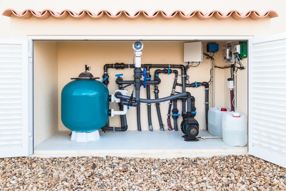A Swimming Pool Filter is Sitting Inside of a Garage — The Pump Doctor In Kuluin, QLD