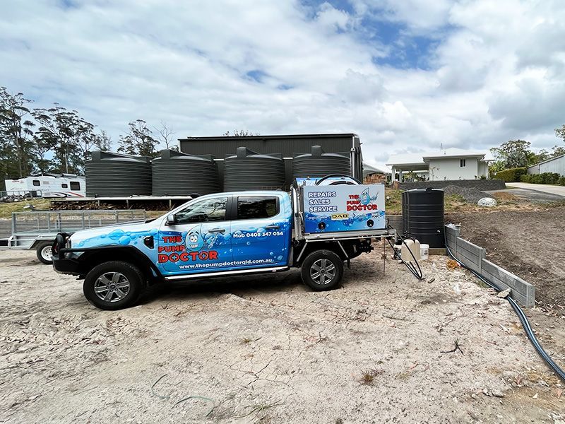 A Blue and White Truck is Parked in a Dirt Lot — The Pump Doctor In Glenview, QLD