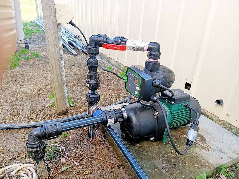 A Water Pump is Sitting on the Ground Next to a Wall — The Pump Doctor In Kuluin, QLD