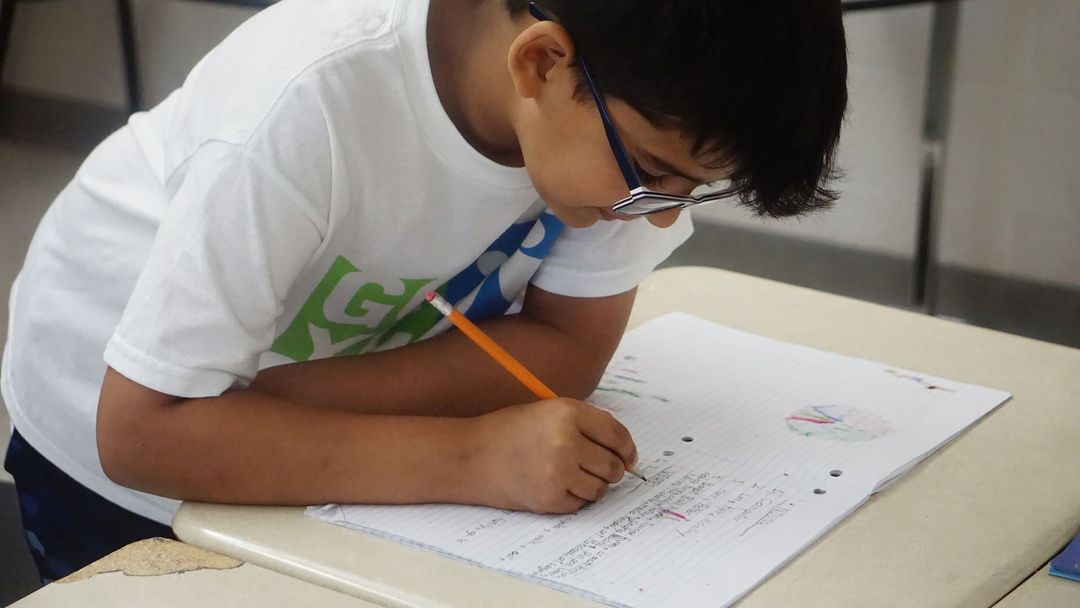 A boy in a black hoodie with the letter s on it