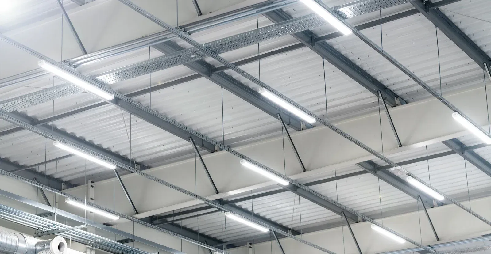 The ceiling of a building with lots of lights hanging from it.