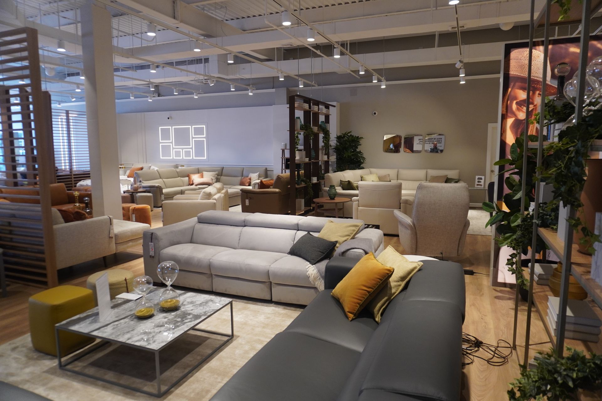 Interior of a furniture store displaying various sofas, chairs, and decor under bright lighting.