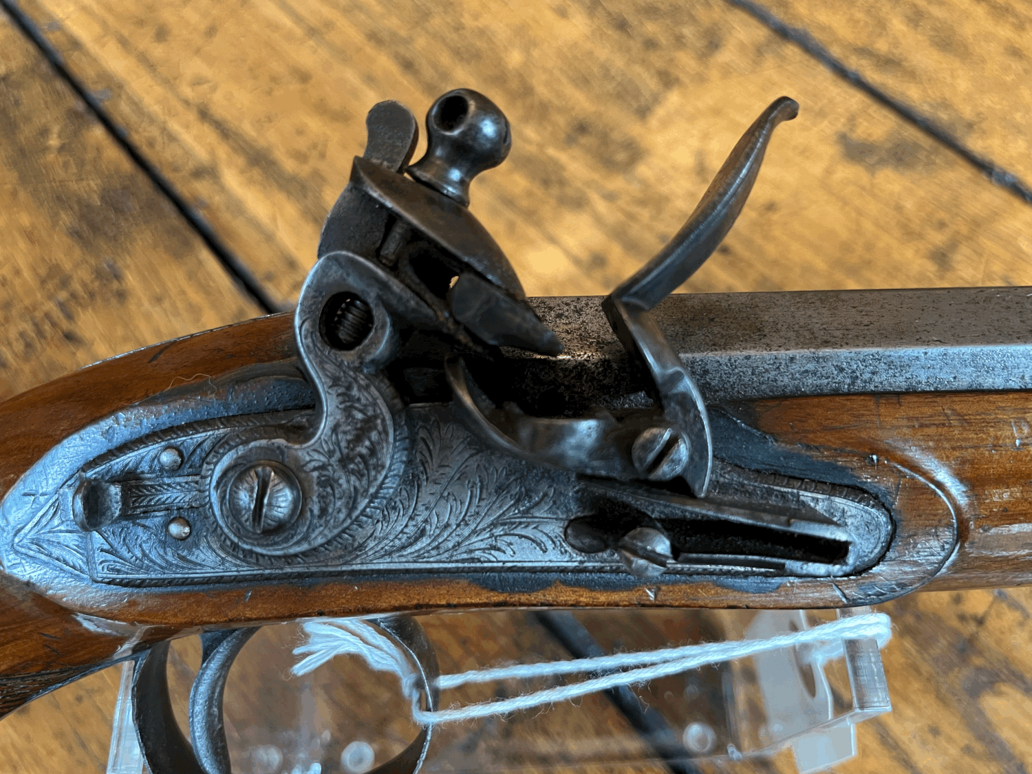 An antique flintlock pistol is sitting on a wooden table.