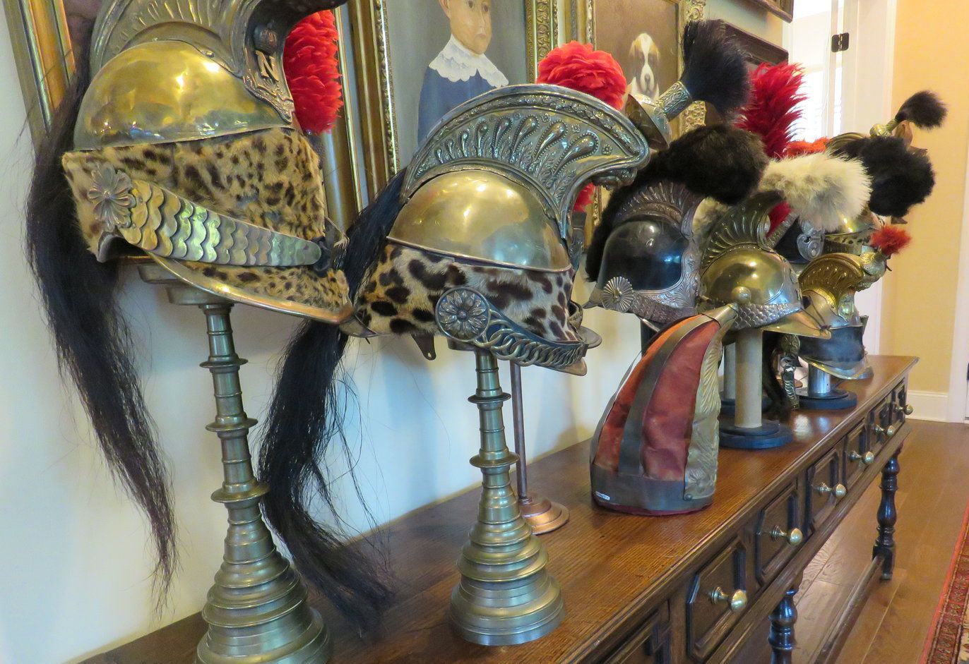 A row of antique helmets are sitting on a wooden table.