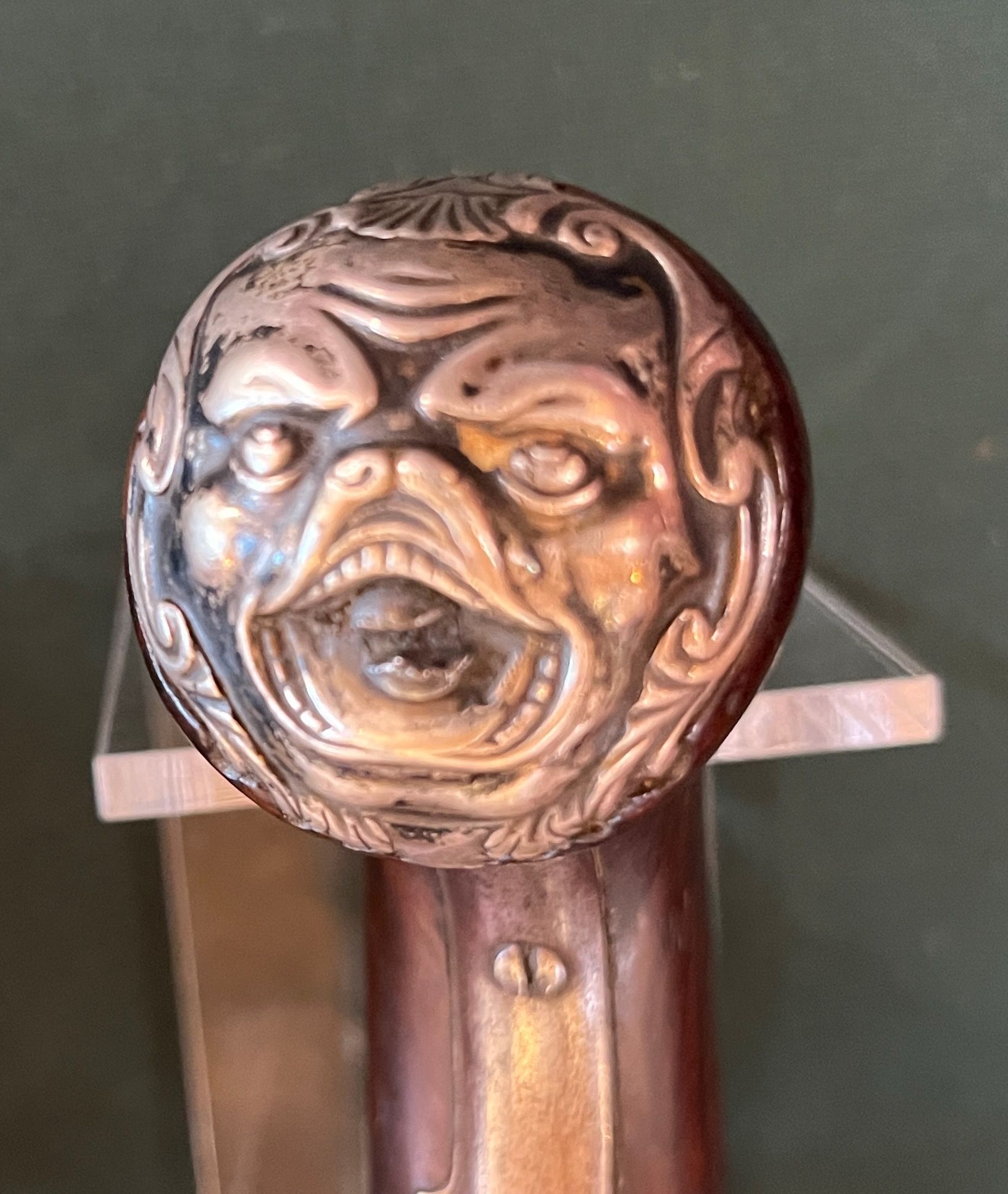 Antique flintlock pistol with a wooden handle on a green surface.
