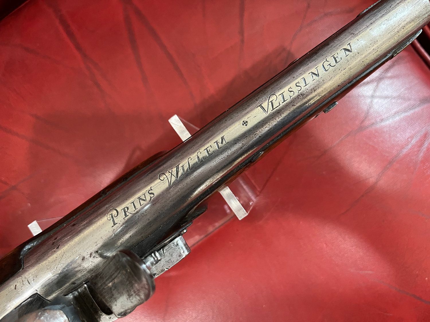 Close-up of a metal barrel with inscribed text: 