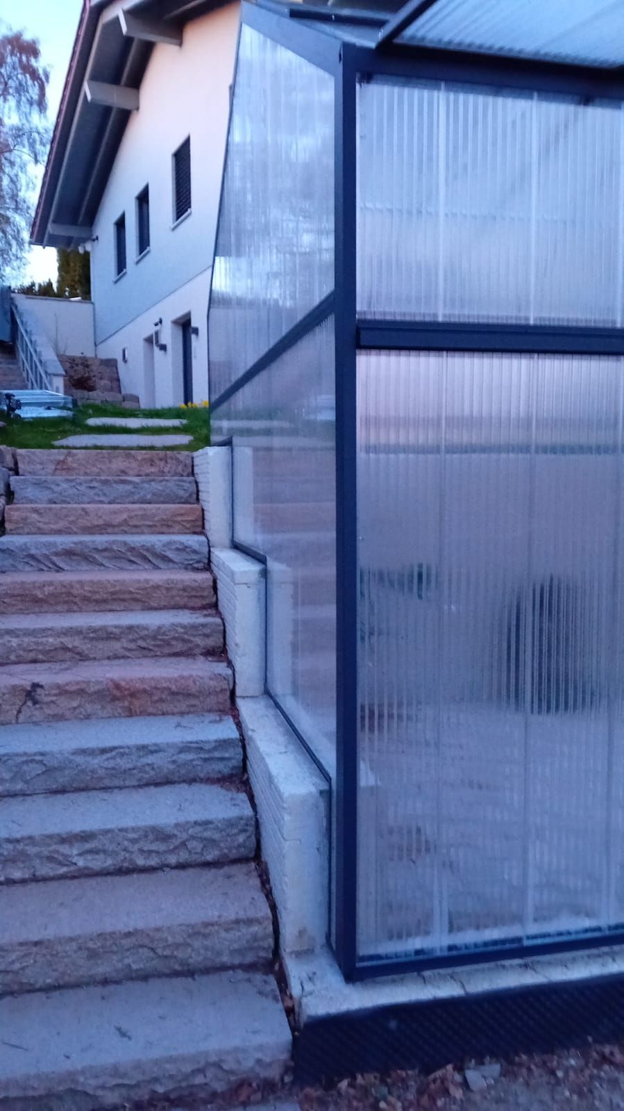 Freistehendes Gewächshaus mit stufigem Fundament und Klappelmenten und anthrazit Farbe, 3,5x7m groß.
