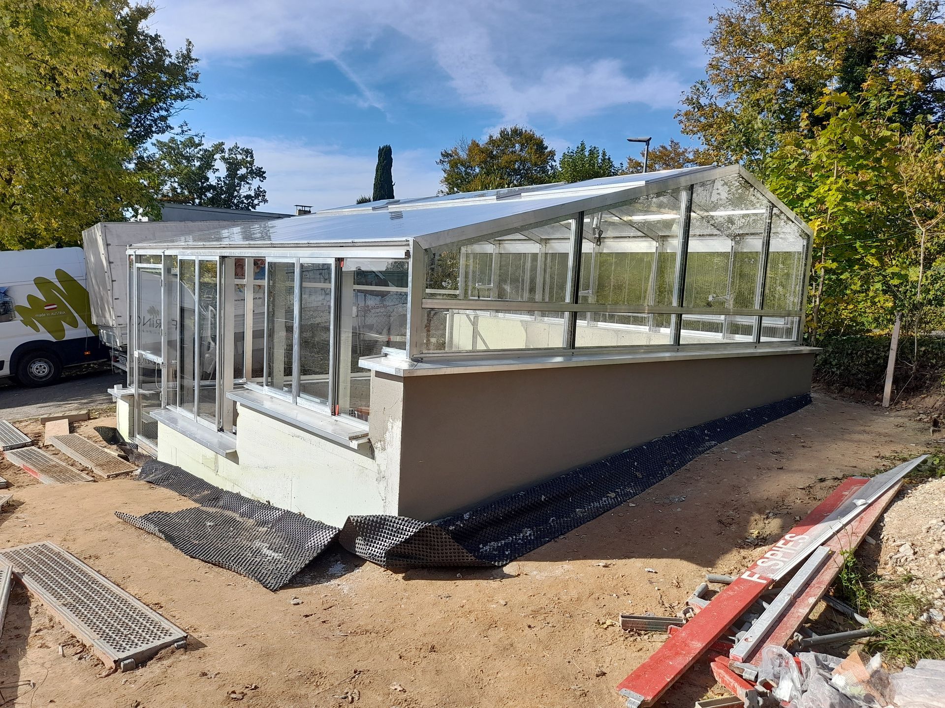 Freistehendes Gewächshaus mit asymetrischem Satteldach und stufigem Fundament. Komplett in Echtglas Ausführung.