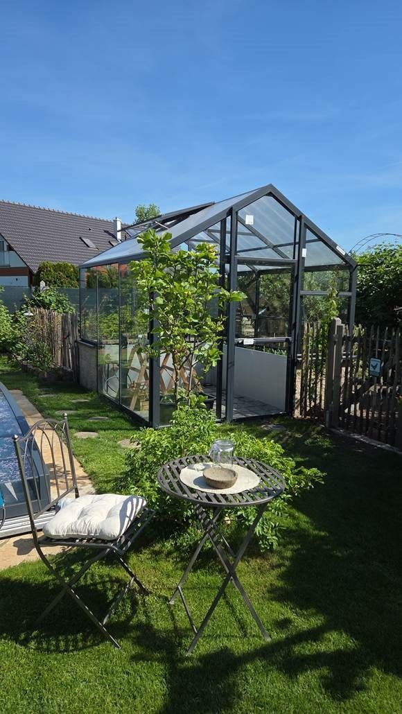 Hochbeet Gewächshaus mit stufigem Fundament, 3,3x3m groß. Seitenwände aus Echtglas, Profile in Farbe anthrazit.