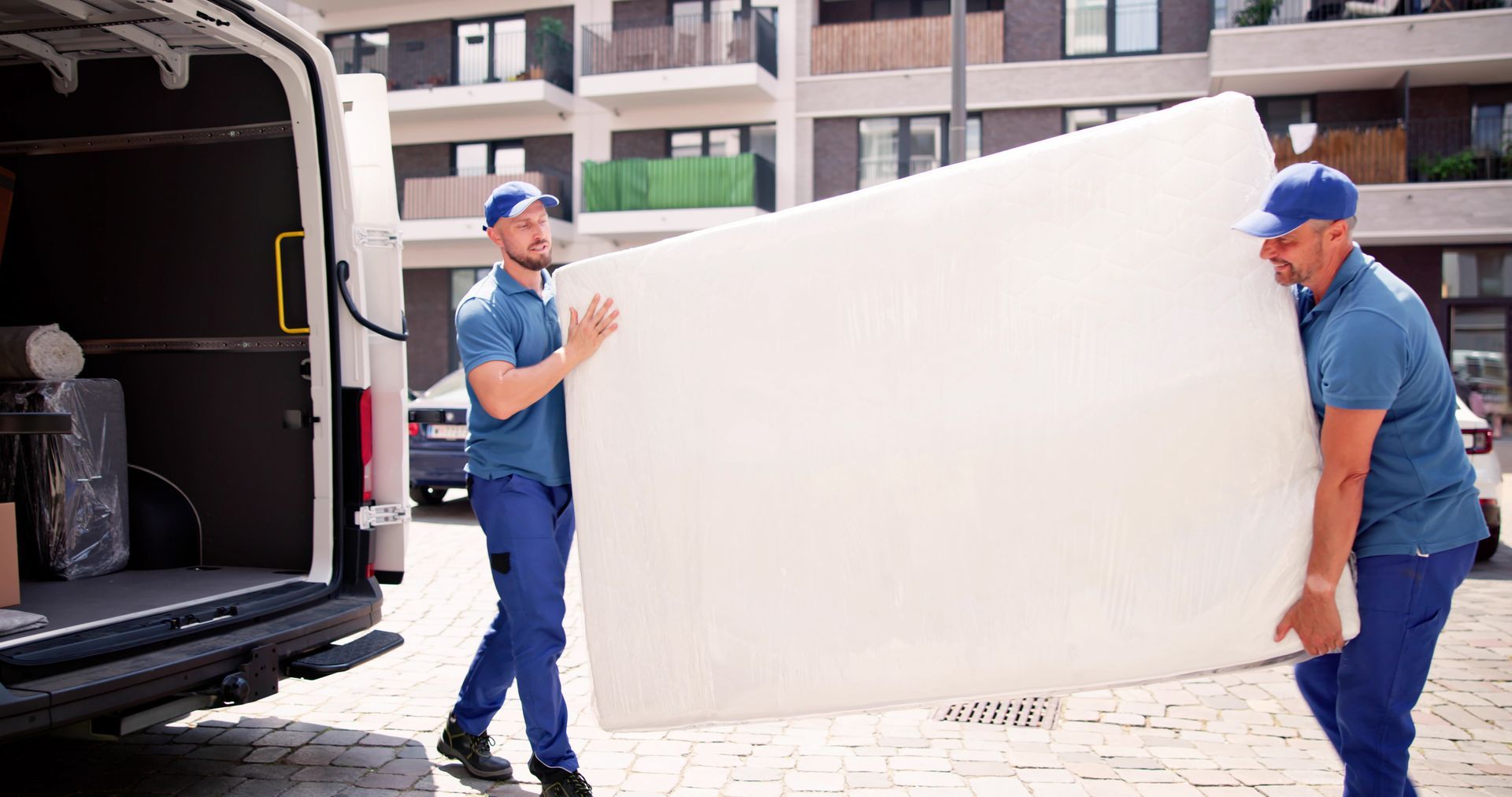 Two Men Are Carrying A Large Mattress — Aiken, NC — Aiken Junkmaster