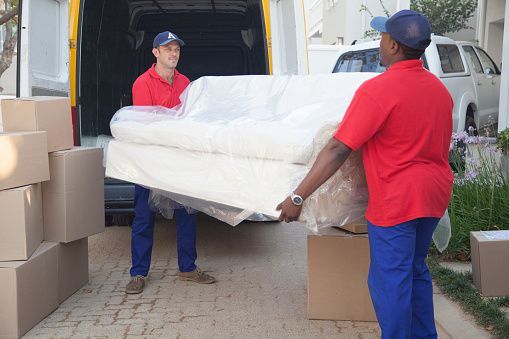 Two Men Are Carrying A Sofa Out Of A Van — Aiken, NC — Aiken Junkmaster