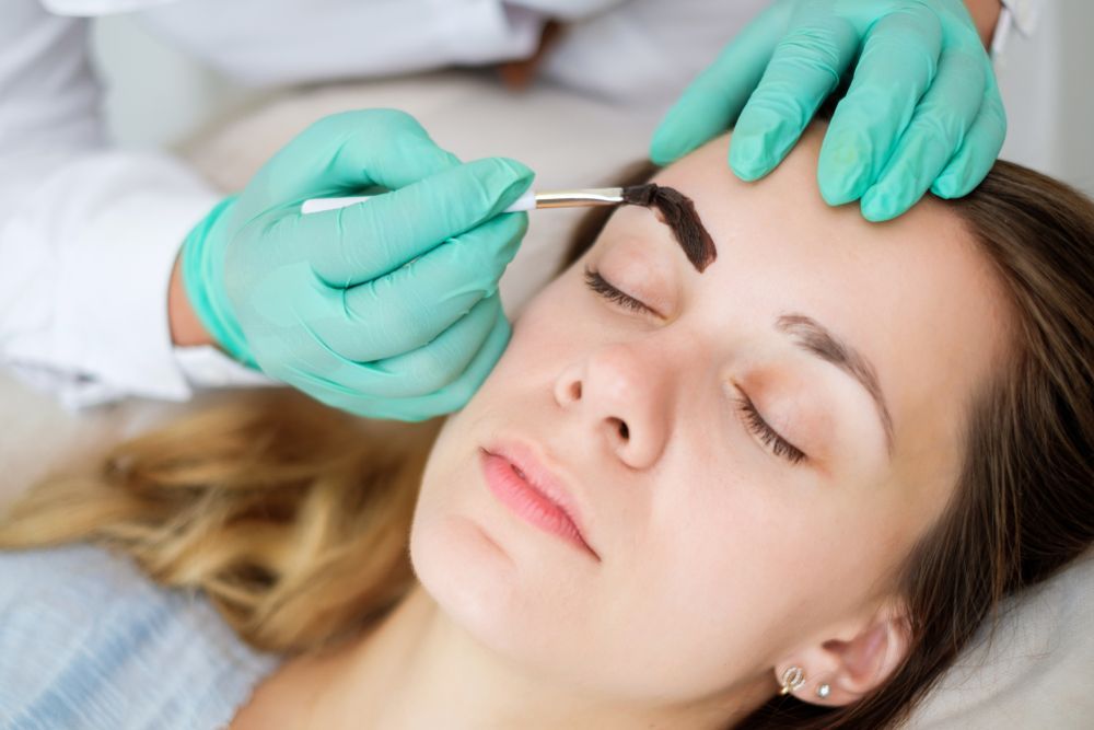 Gloved Hands Shaping Eyebrows with A Brow Brush as A Woman Lies with Eyes β Villa Nails & Beauty in Proserpine, QLD