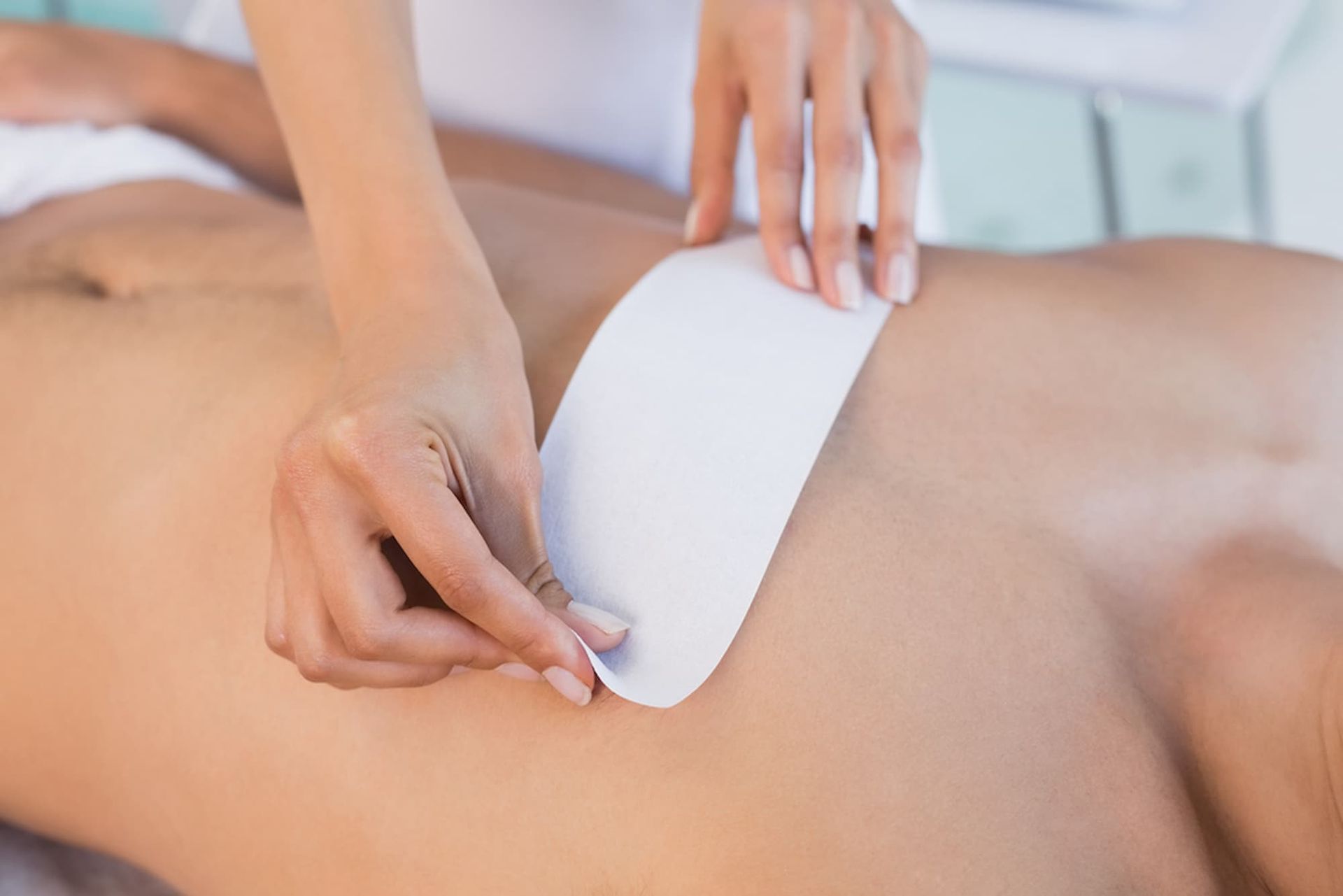 A Woman Is Waxing a Man's Chest in A Spa โ Villa Nails & Beauty in Cannonvale, QLD