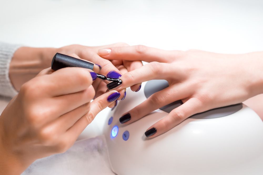 Manicured Nails Being Painted Black with A Purple Polish Bottle β Villa Nails & Beauty in Airlie Beach, QLD