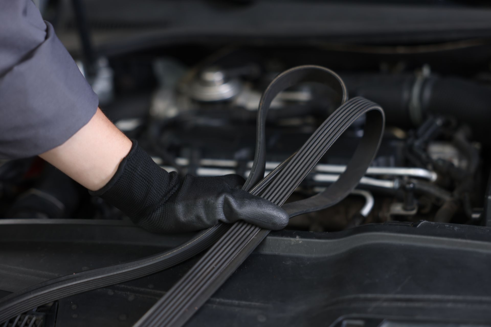 close up image of car timing belt in a mechanic's hand