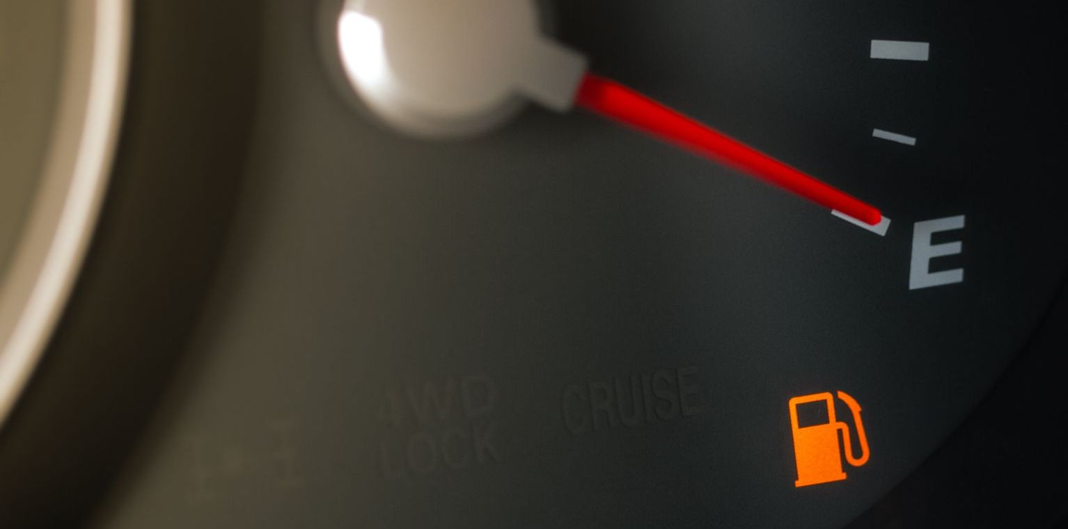 Fuel guage shownig that the car tank is empty; a red ticker is pointing downwards to the