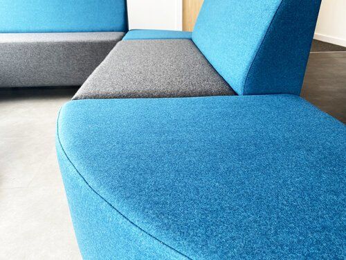 Close up of the waiting area in Andrew Dodds Autocare where there is a blue and grey comfortable couch.