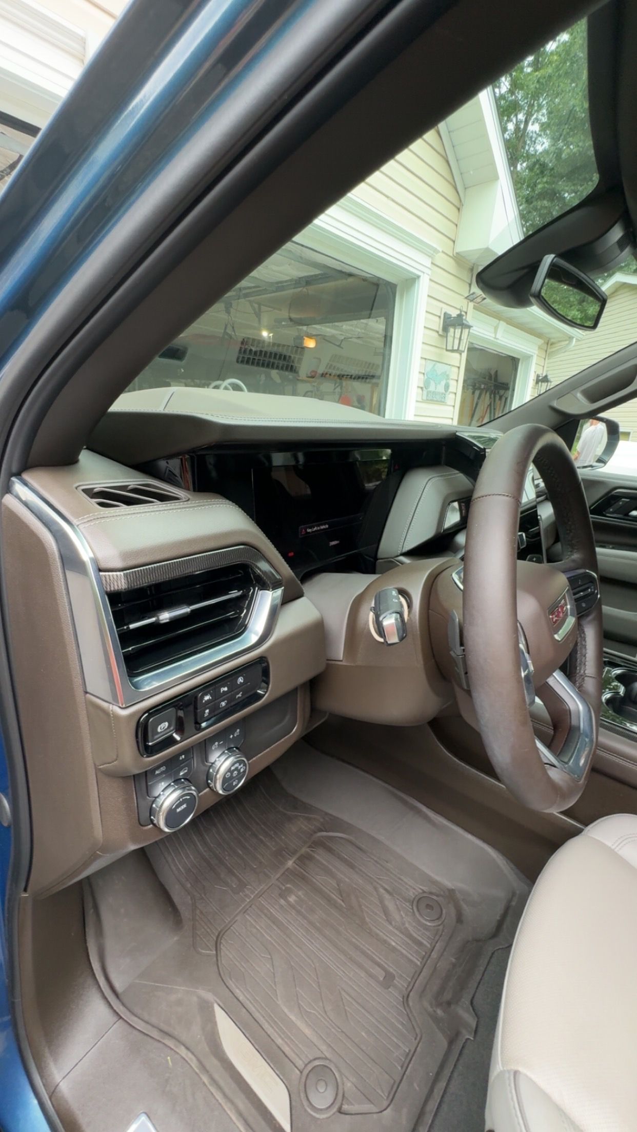 Interior view of a vehicle's driver-side dashboard, showing the steering wheel, instrument cluster, and air vent.