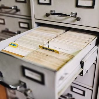 Open filing drawer filled with manila folders in a cabinet