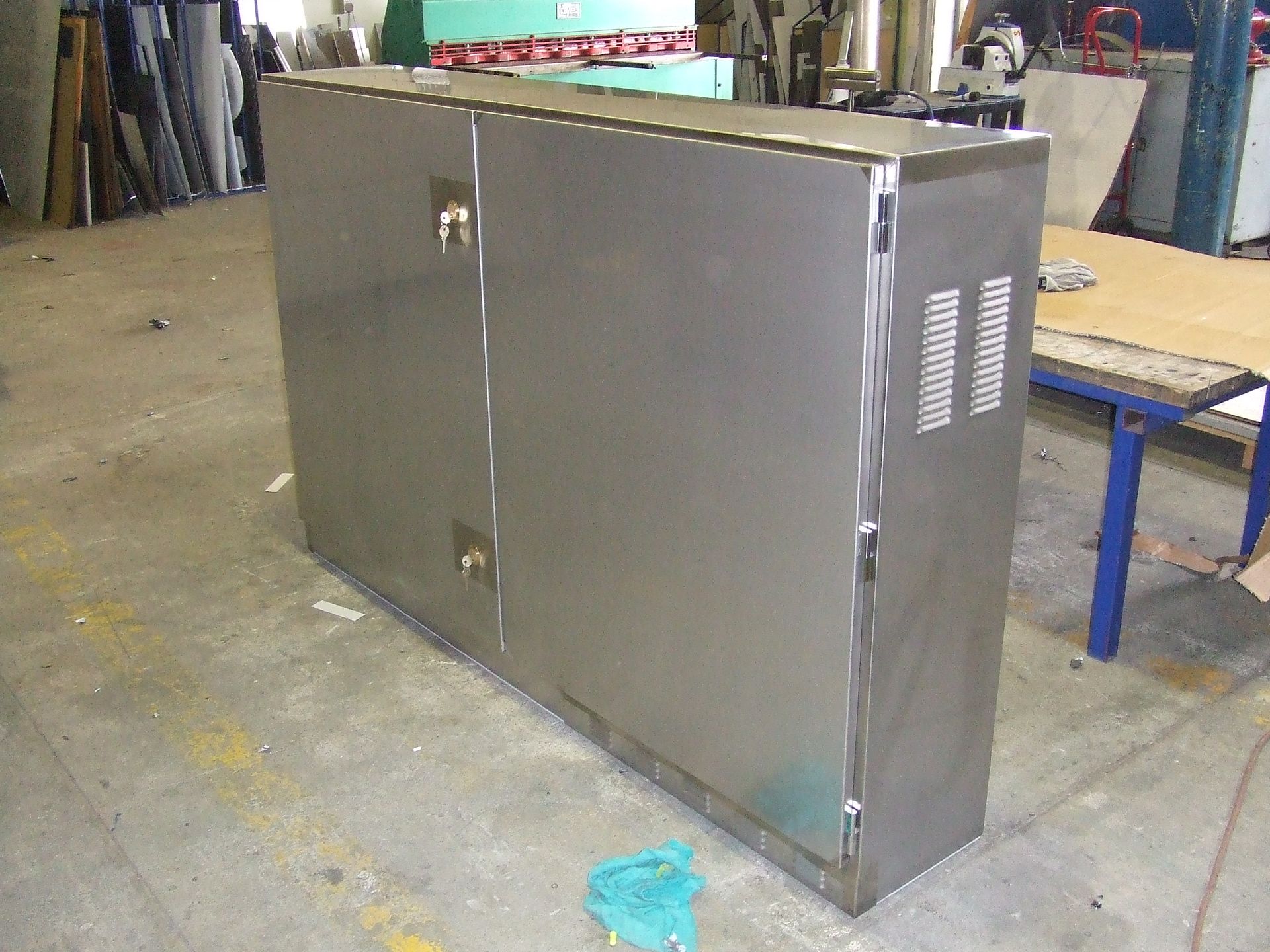A large, rectangular, stainless steel cabinet on a concrete floor.