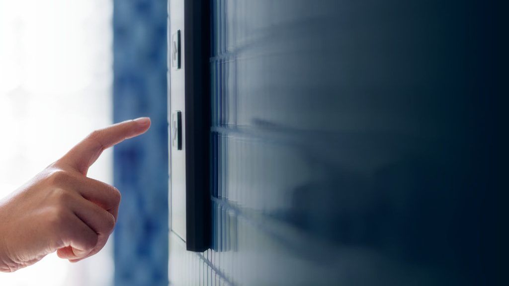 A person is pressing a button on a television.