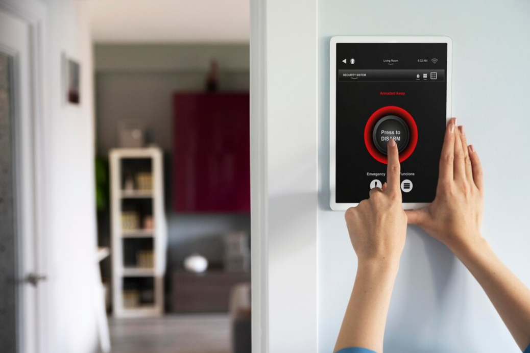 A person is using a tablet to control a home security system.