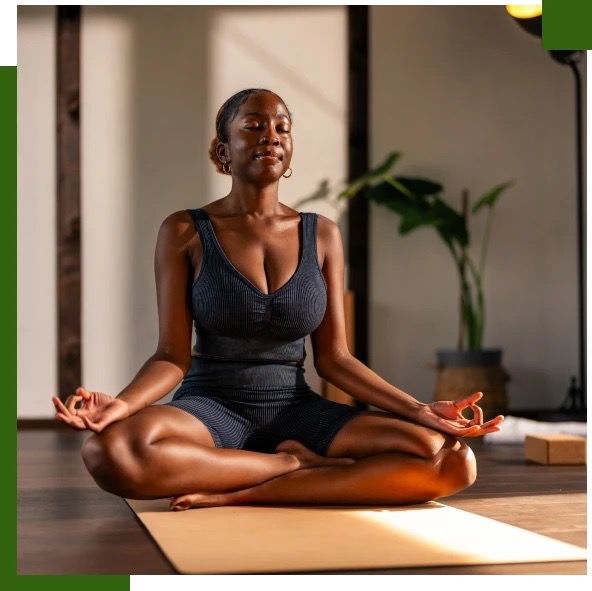 Woman meditating in a lotus position on a yoga mat.