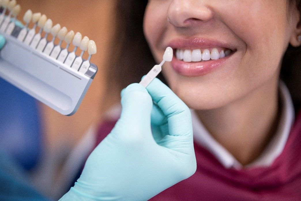 A Dentist Examining a Patient’s Tooth Shade | Pros and Cons of Veneers