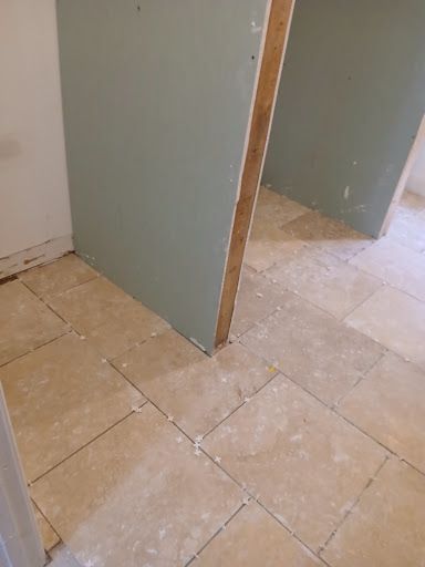 Partially framed drywall partition in a tiled interior room under construction