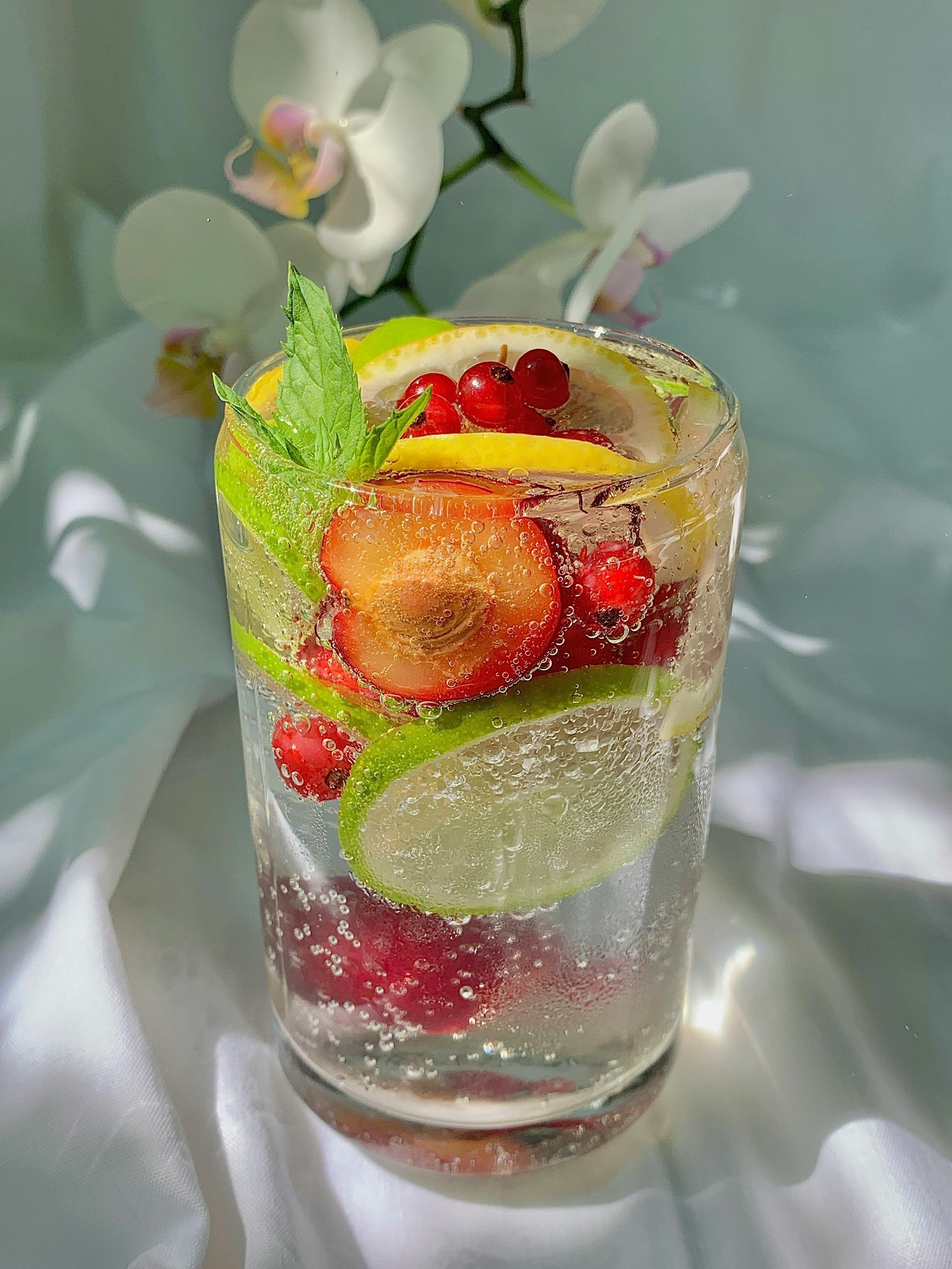 sparkling water with a lime, peaches and berries