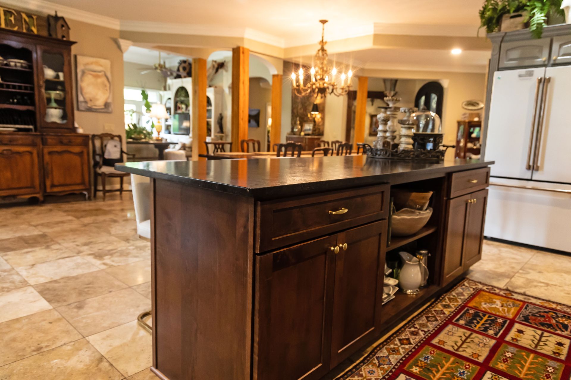 Warm kitchen with dark wood island, cream cabinets, and tiled floor