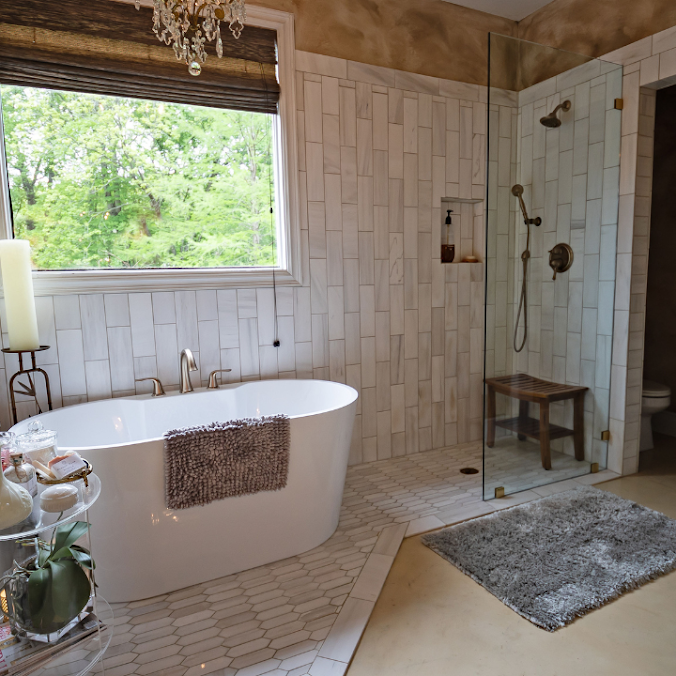 Spacious bathroom with a freestanding tub, walk-in shower, and a large window overlooking greenery.