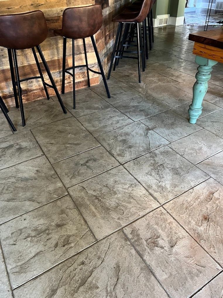 Stone-tile café floor with wooden bar stools and a turquoise table leg
