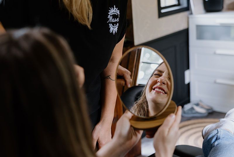 Happy Moser client looking in a mirror