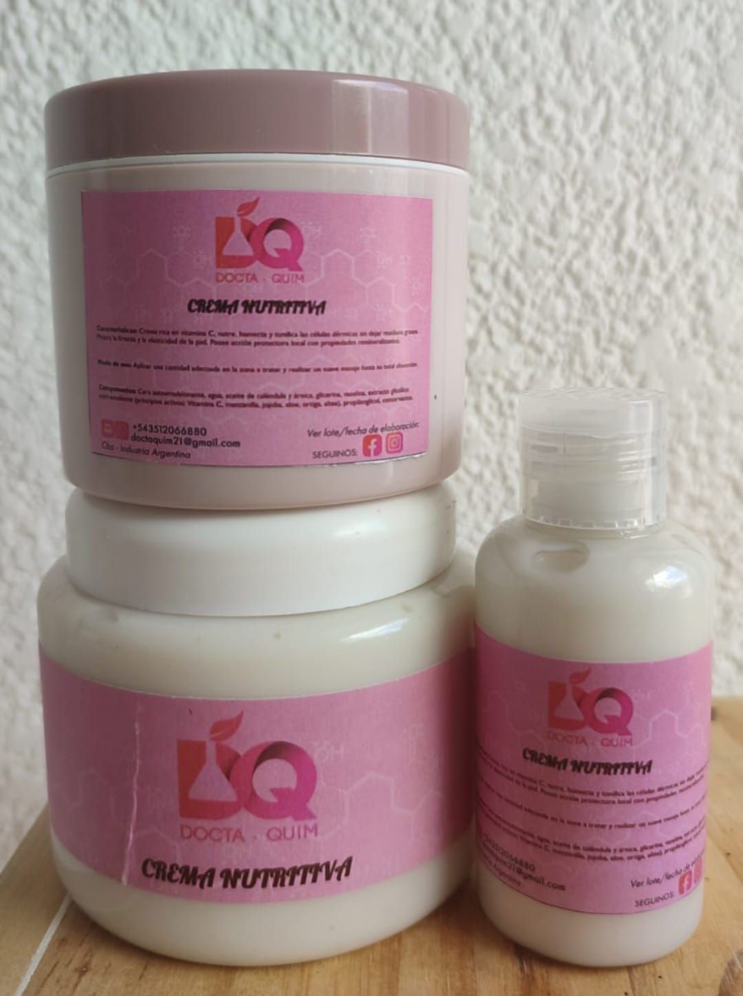 Tres tarros de cosméticos blancos con etiquetas rosas.